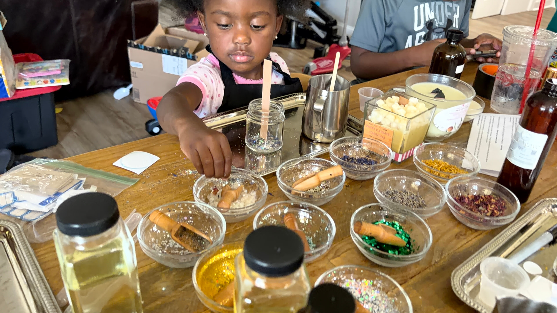 A child decorating her candle with botanicals at a kids party