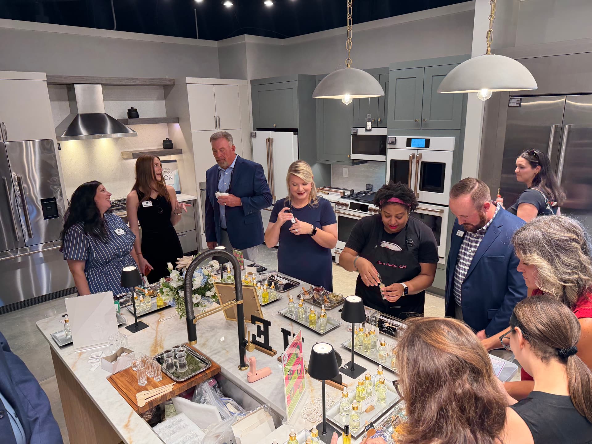 Guests blending fragrance oils with a She Is Experiences host at a Ferguson Home corporate event