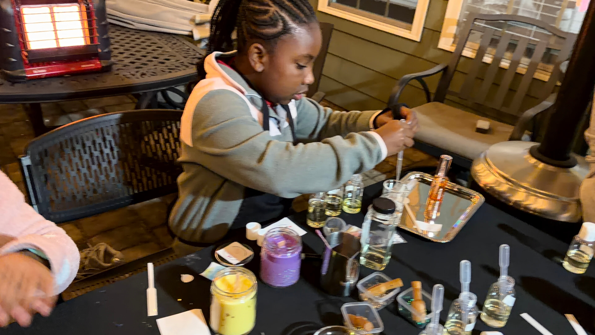 A guest making a candle at an outdoor kids candle-making party